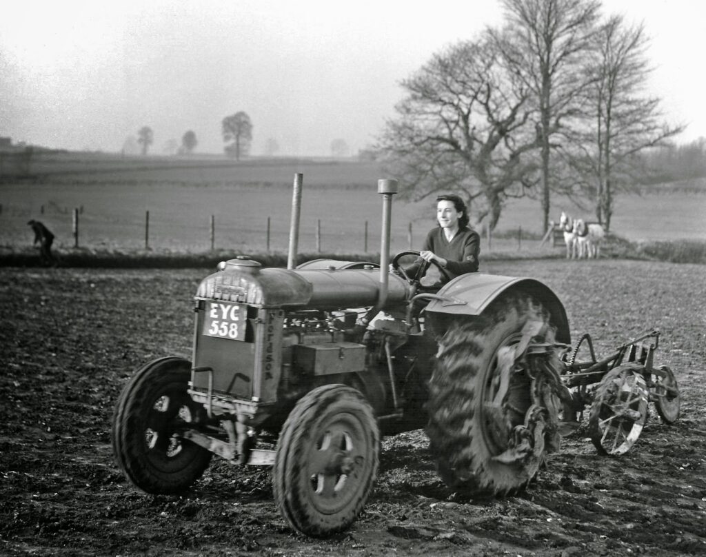 Land girl driving a vintage tractor